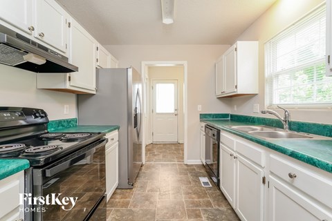 A kitchen with a stove top oven and a refrigerator.