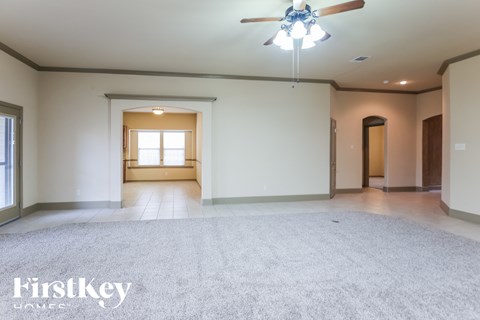 A spacious room with a ceiling fan and a window.