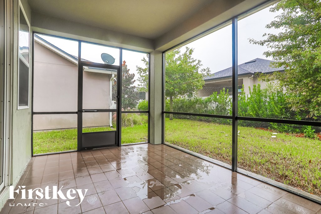a view of the backyard from the living room of a house with large glass windows