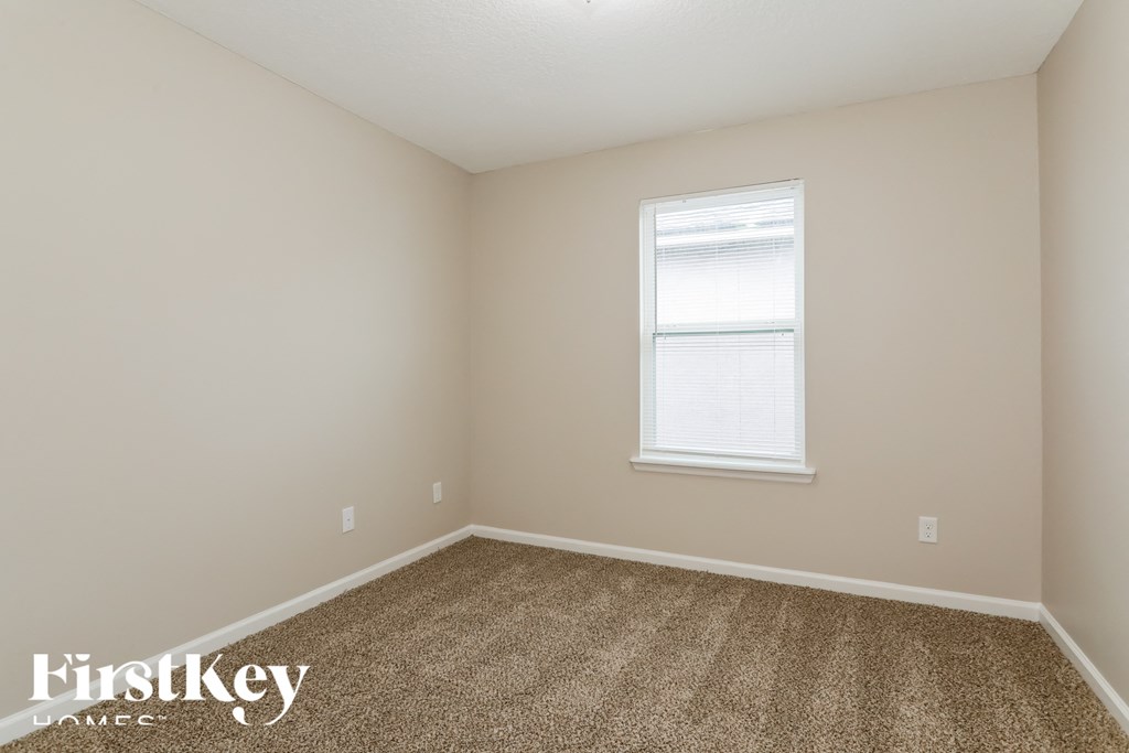 a bedroom with a carpeted floor and a window