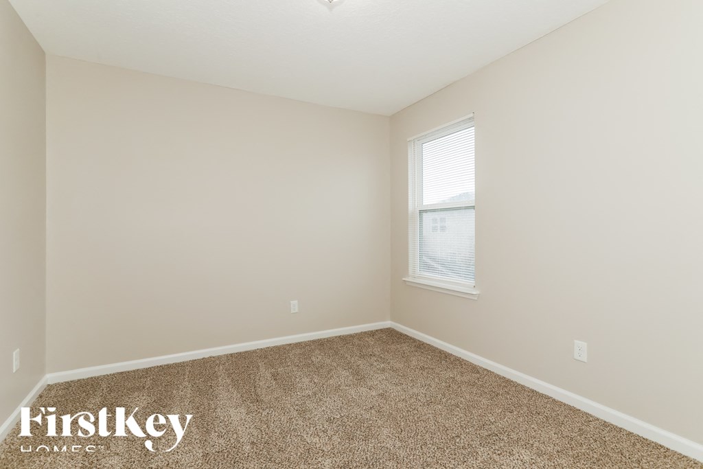 a bedroom with a carpeted floor and a window