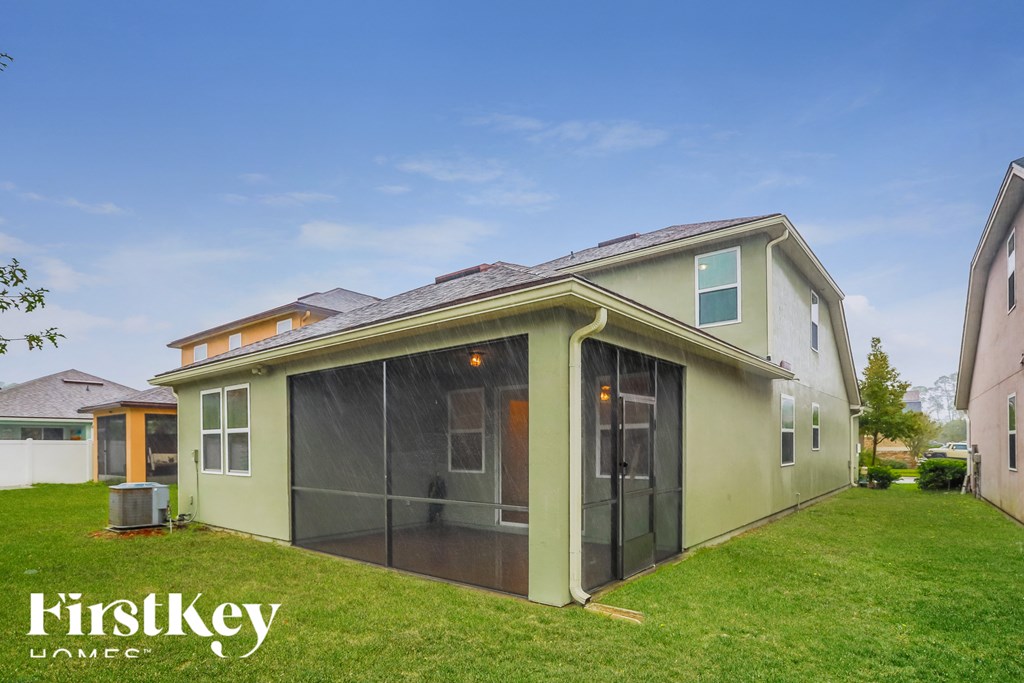 a green house with glass doors and a lawn