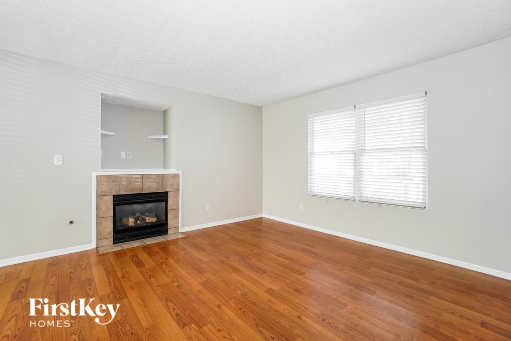 A room with a fireplace and wooden floors.