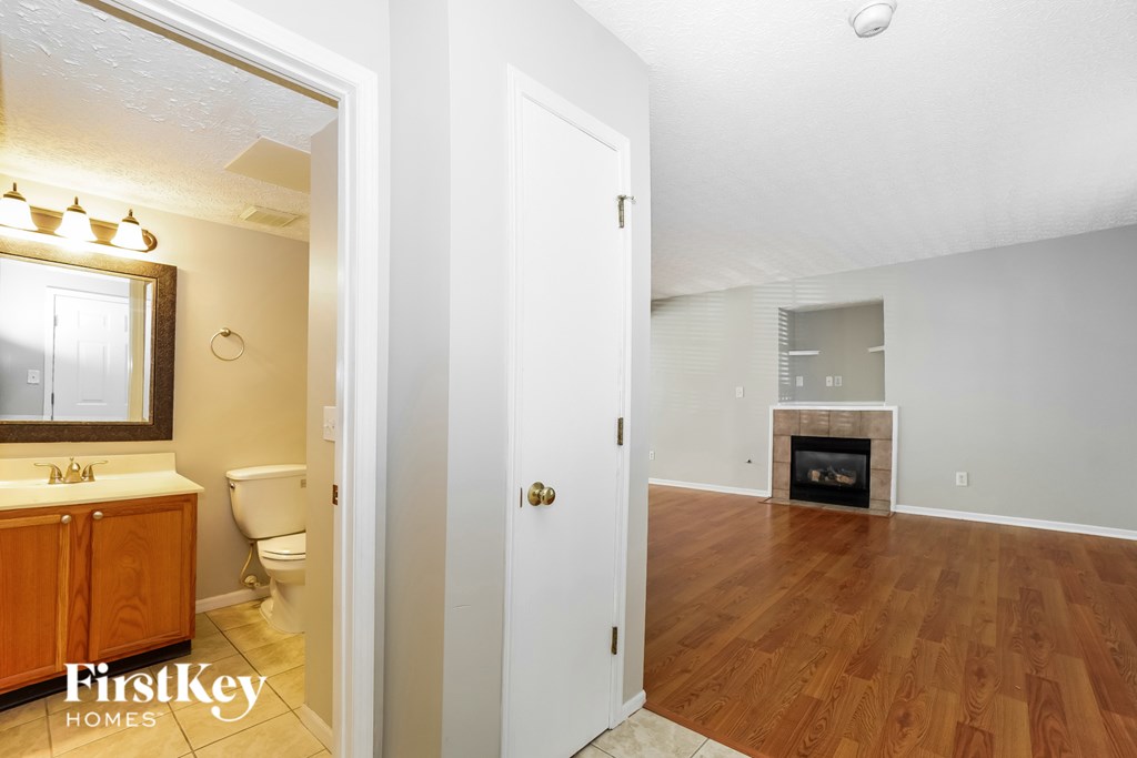 A bathroom with a mirror, sink, and toilet is shown.
