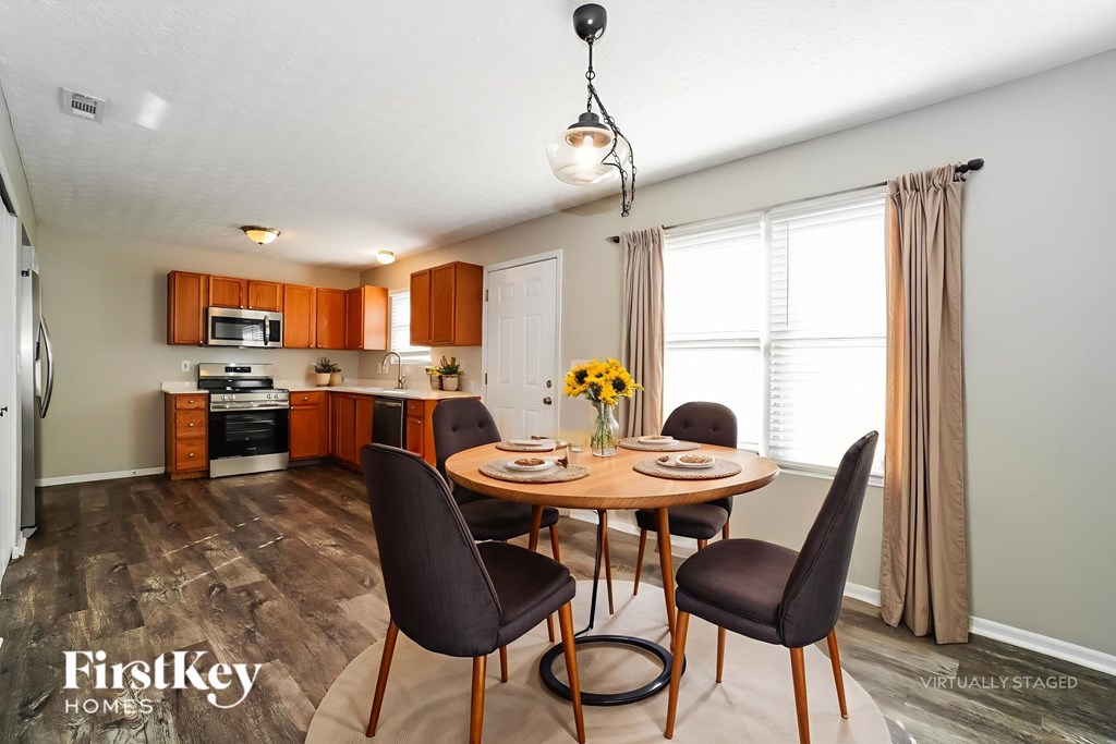 A dining room with a round table and chairs.