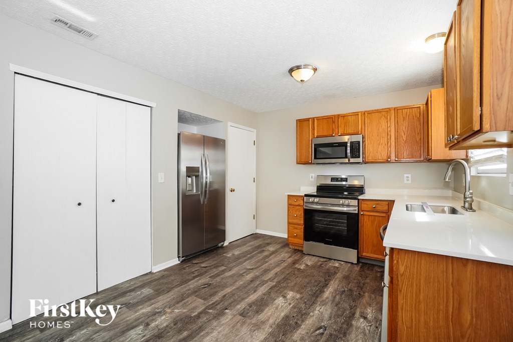 A kitchen with wooden cabinets and a white counter top.