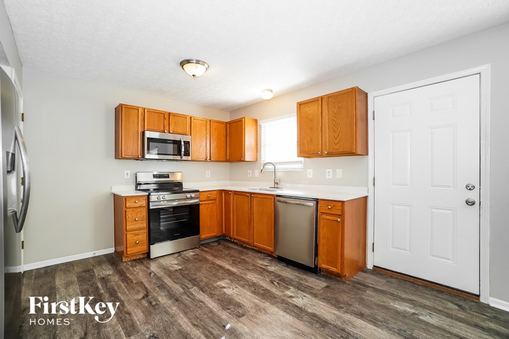 A kitchen with wooden cabinets and a white door.
