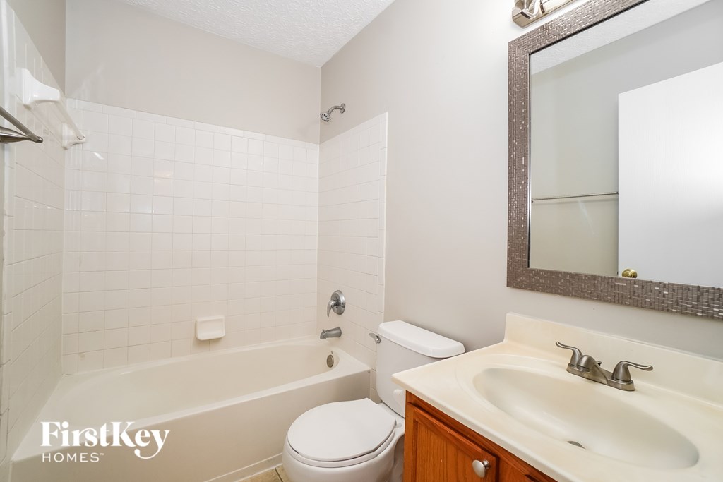 A white bathroom with a toilet, sink, and tub.