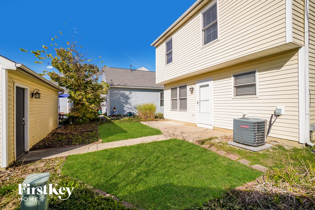 A small grassy area in front of a house with a FirstKey Homes logo.