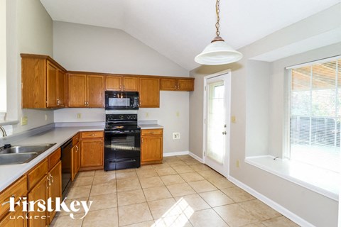 a kitchen with wooden cabinets and black appliances and a window