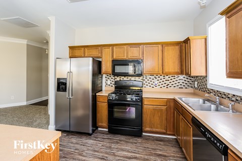 A kitchen with wooden cabinets and a black oven.