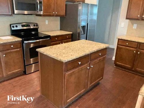 A kitchen with wooden cabinets and a granite countertop.