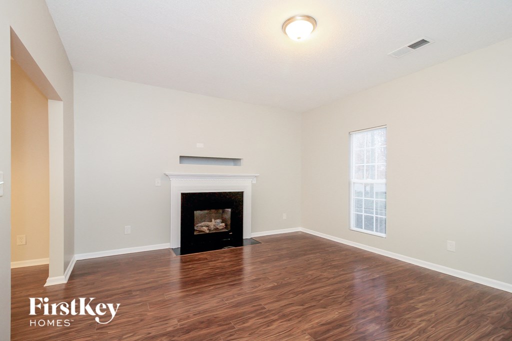 the living room with wood flooring and a fireplace