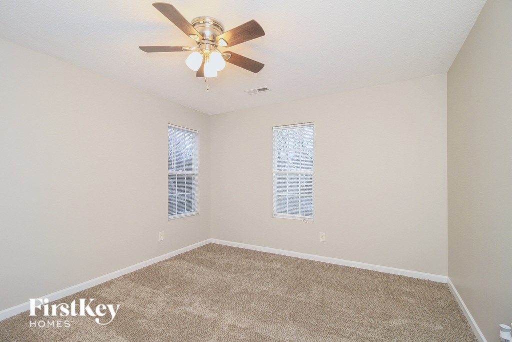 the living room of an empty house with a ceiling fan