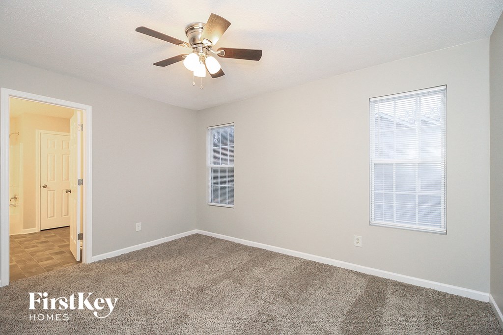 the living room of an empty house with a ceiling fan