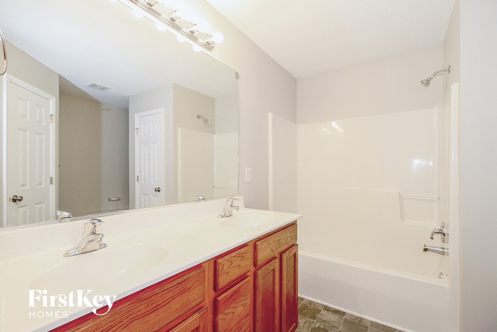 a bathroom with a sink and a shower and a mirror