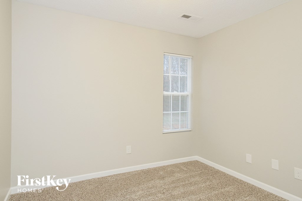 a empty room with carpet and a window