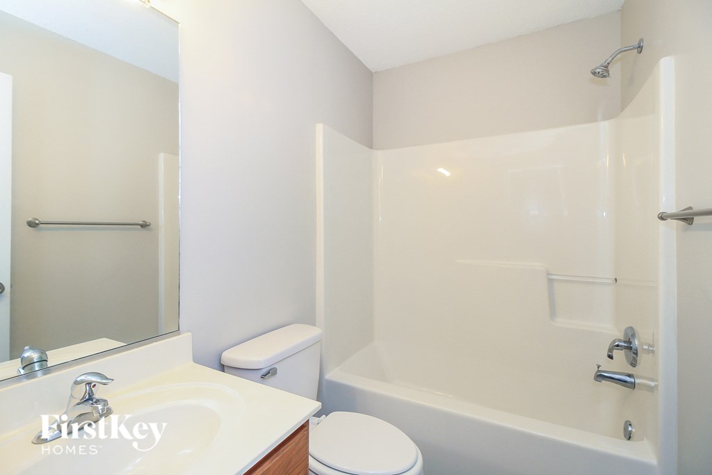 a white bathroom with a white toilet and a tub and a sink