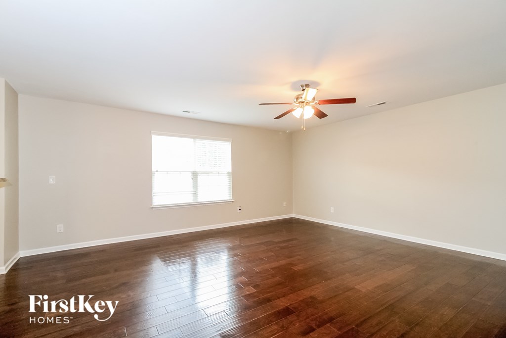 A room with wooden floors and a ceiling fan.
