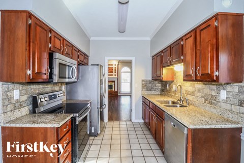 a kitchen with wooden cabinets and granite counter tops and stainless steel appliances