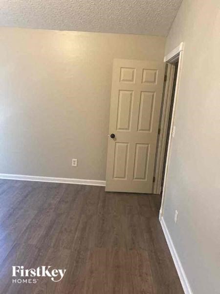 A room with a wooden floor and a white door.