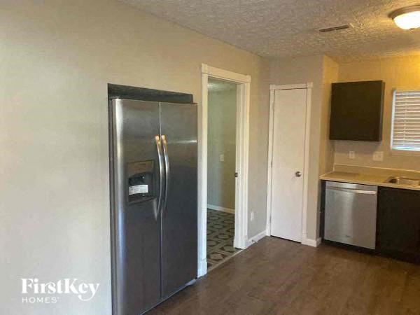 A kitchen area with a stainless steel refrigerator, a microwave, and a dishwasher.