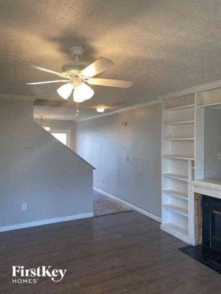 A room with a fireplace and a ceiling fan.