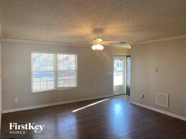 A room with wooden floors and a ceiling fan.