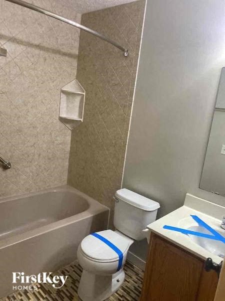 A bathroom with a toilet, sink, and bathtub.