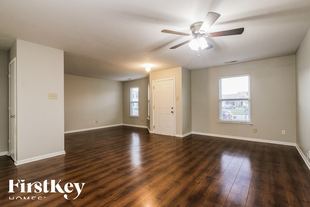 A room with wooden floors and a ceiling fan.