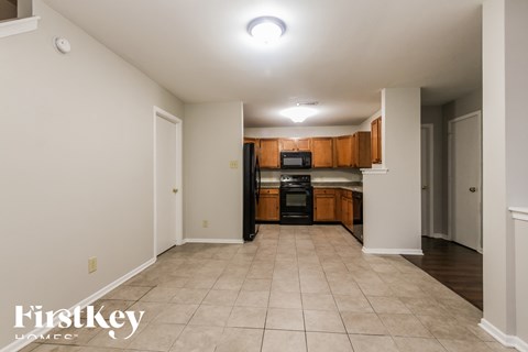 A spacious kitchen with wooden cabinets and a black oven.