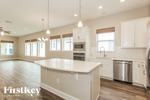A kitchen with a large island in the middle and a stainless steel dishwasher.