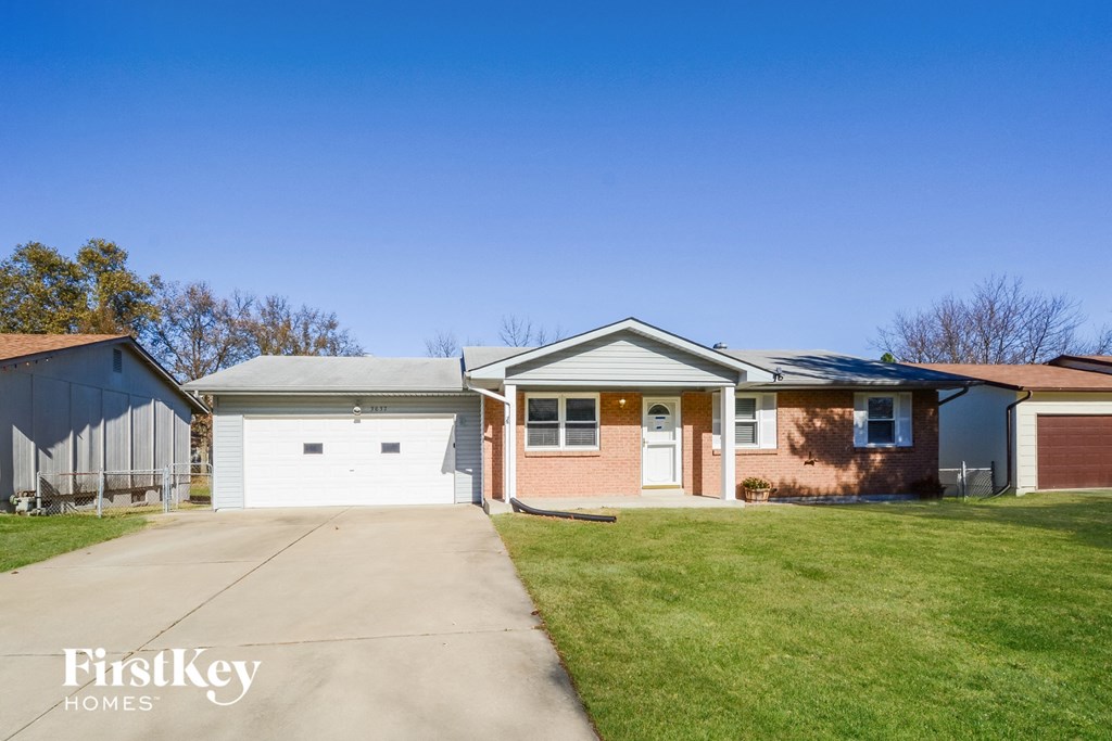 a brick house with a garage and a driveway