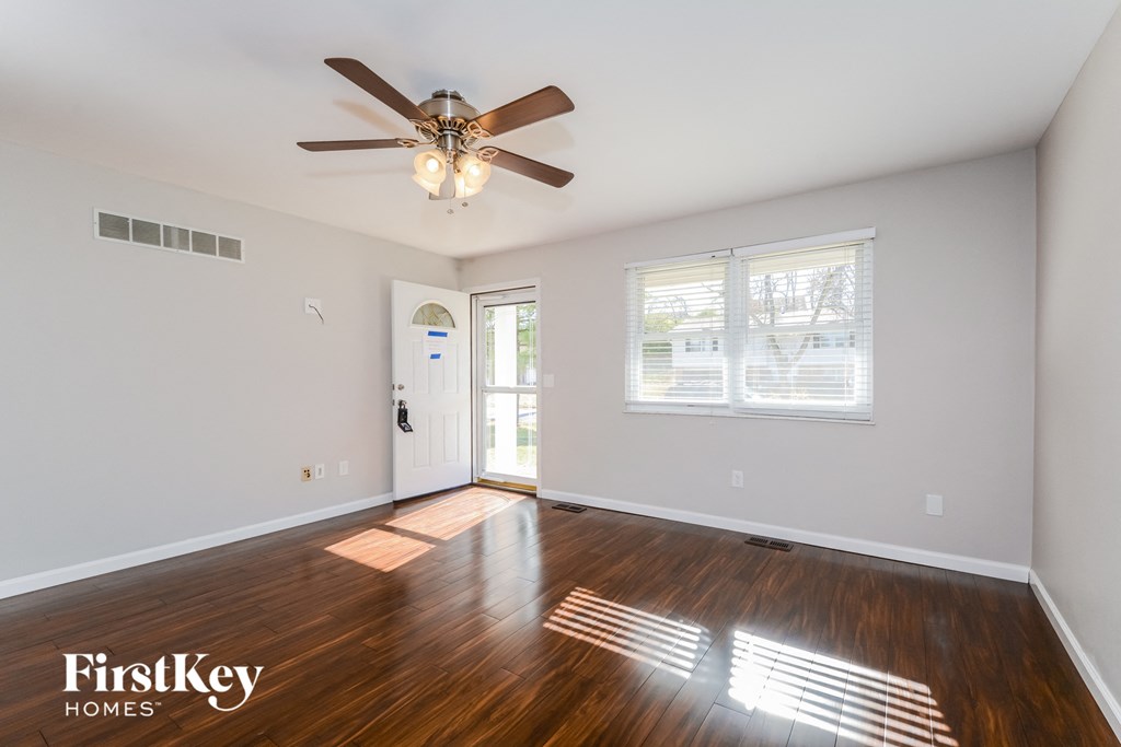 a living room with hardwood floors and a ceiling fan