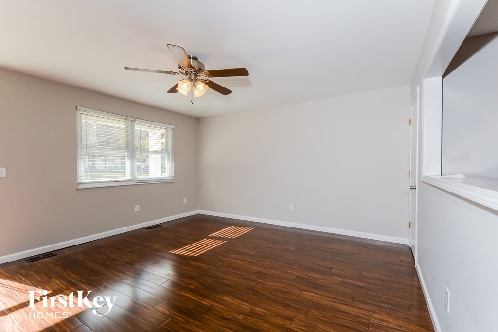 a living room with wood floors and a ceiling fan