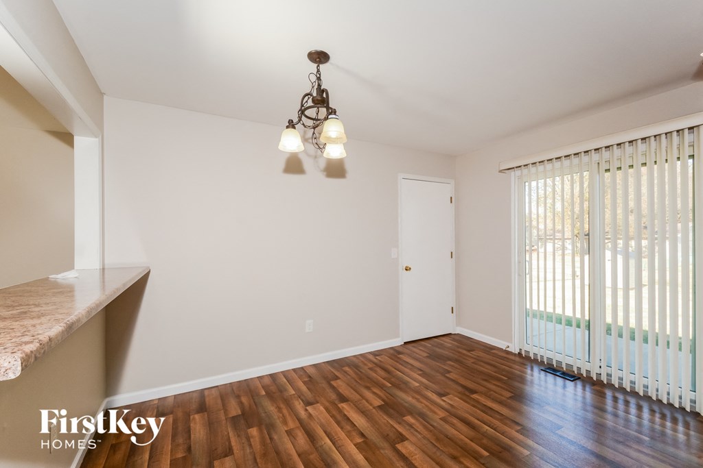 an empty living room with wood flooring and a large window