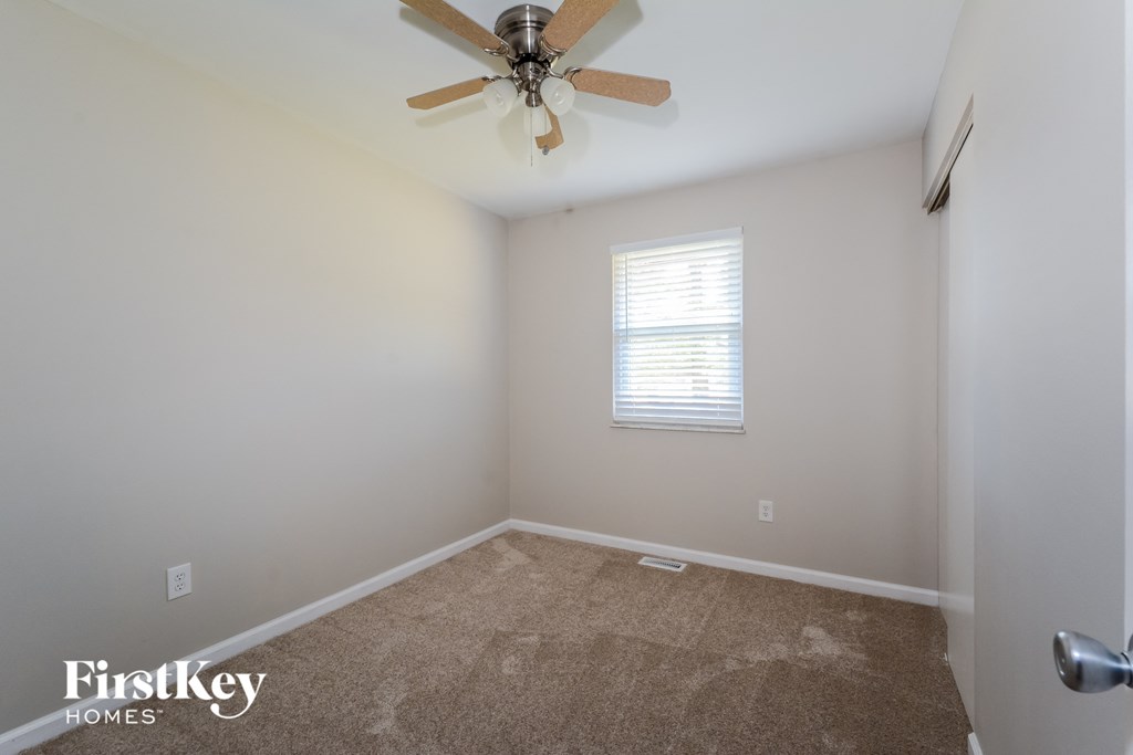 a room with carpet and a ceiling fan