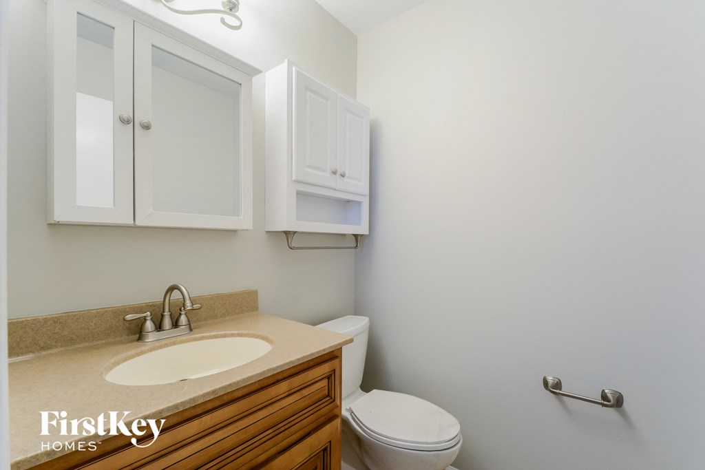 a bathroom with a toilet and a sink and a mirror