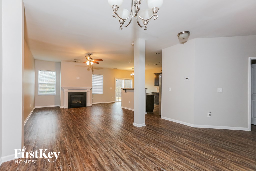 the living room and dining room of an empty house with a fireplace