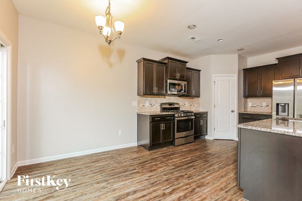 a kitchen with wood flooring and stainless steel appliances