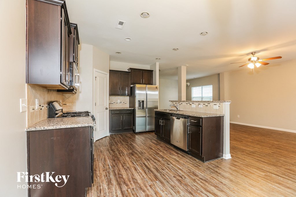 a kitchen with wood flooring and stainless steel appliances