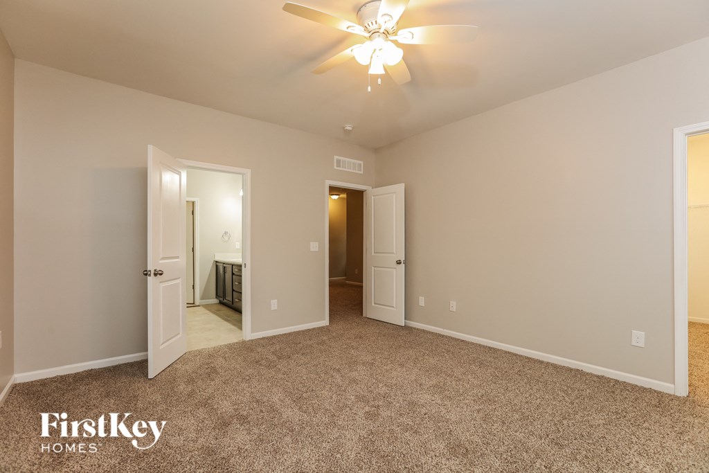 a bedroom with a carpeted floor and a ceiling fan