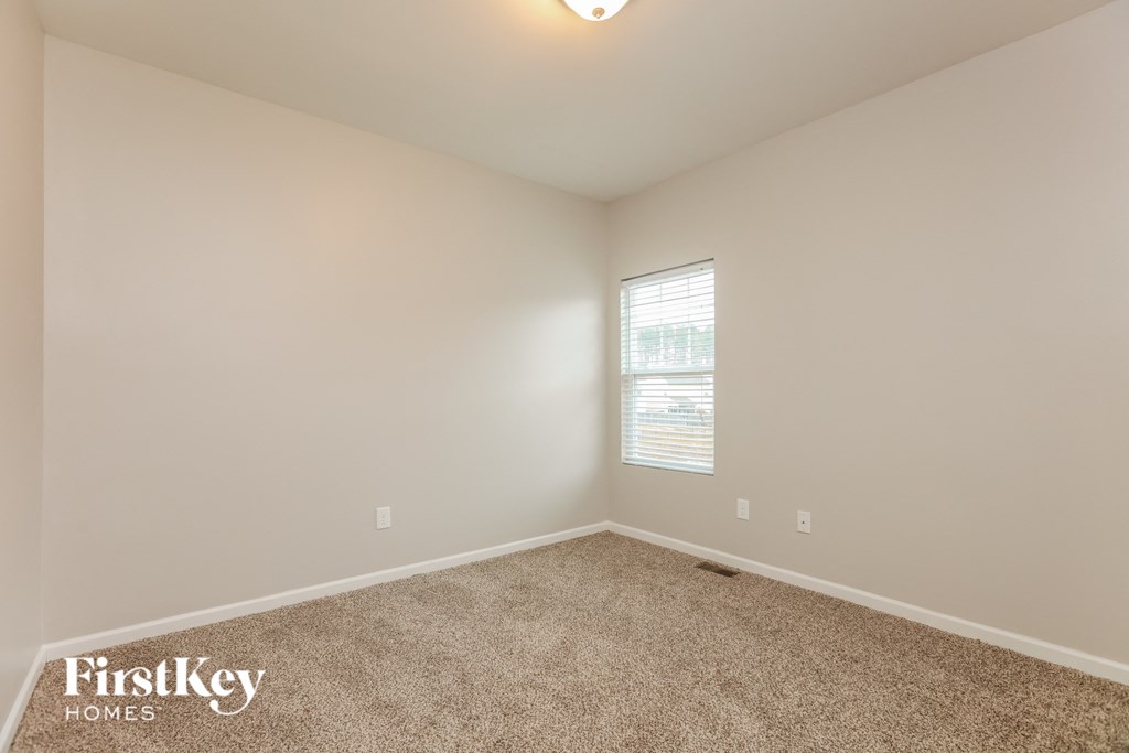 a bedroom with a carpeted floor and a window