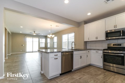 a large kitchen with white cabinets and stainless steel appliances