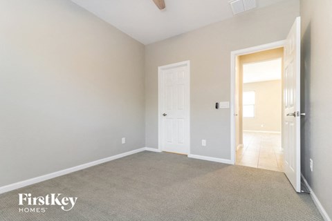 a bedroom with a door to the bathroom and a carpeted floor