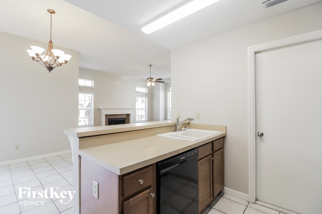 a kitchen with a sink and a door to a living room