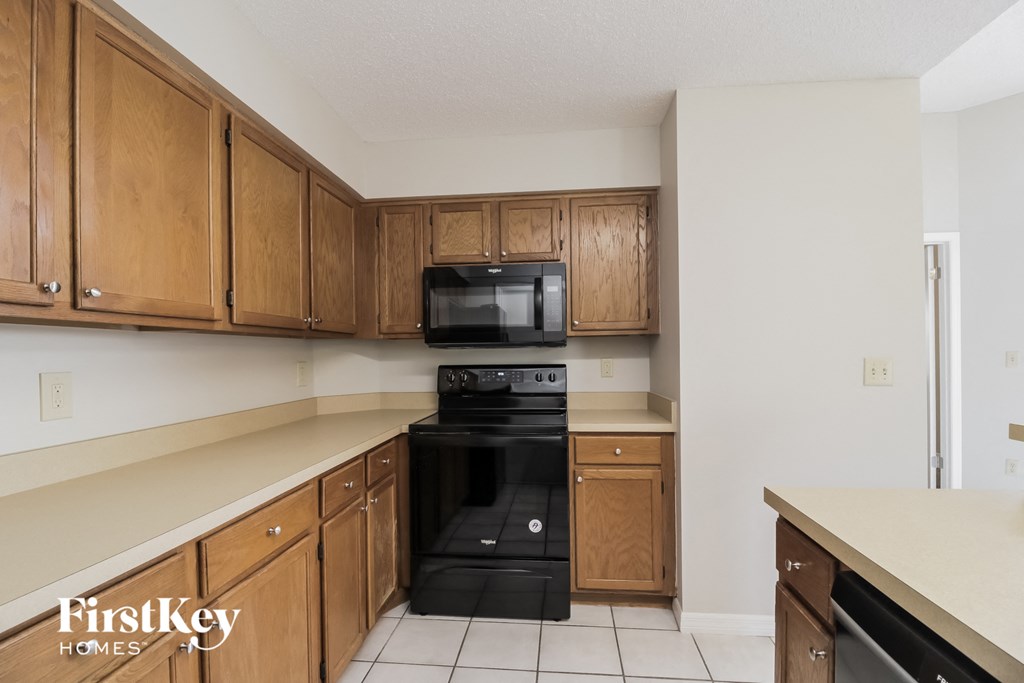 a kitchen with wooden cabinets and black appliances