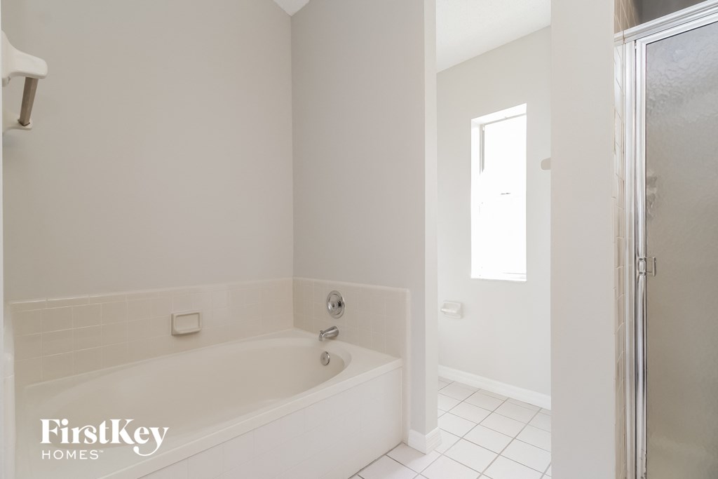a white bathroom with a tub and a shower