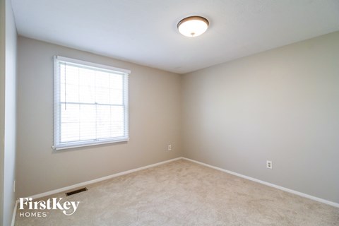 a bedroom with white carpet and a window