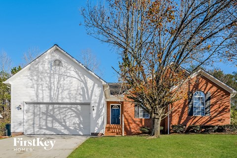 a white and red brick house with a white garage door